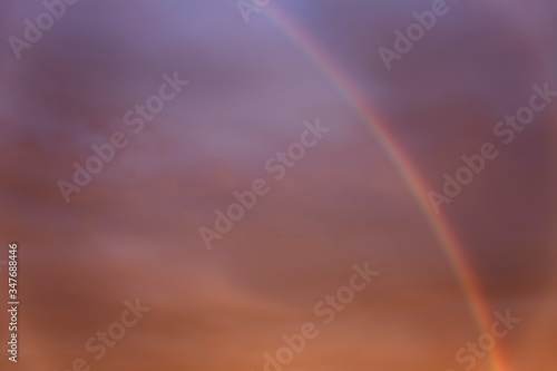 Rainbow in a dramatic sunset sky. Great scenery. Space for text. Background. Blurred.
