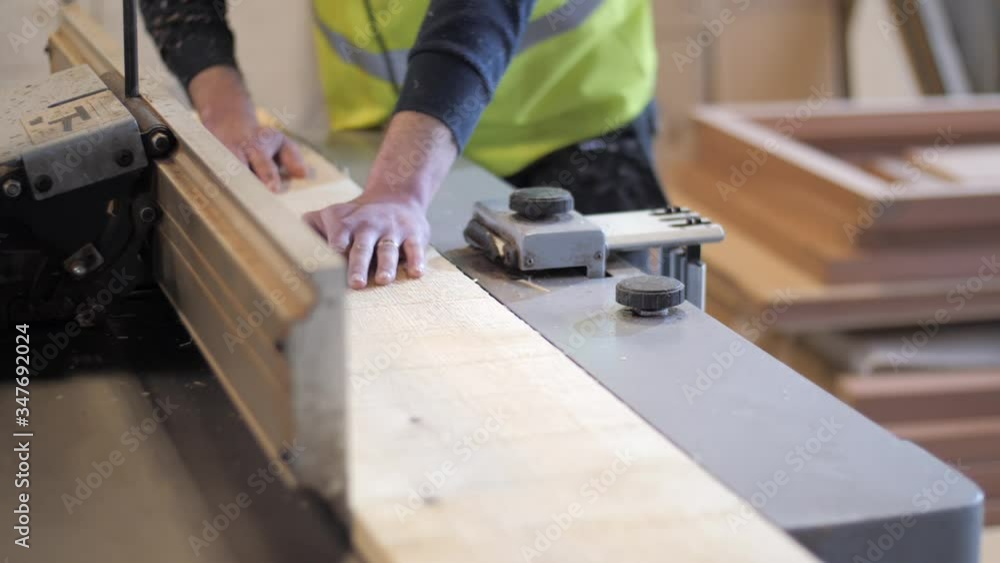Woodworker processing timber in a wooden workshop. Woodworker processing timber in a wooden workshop.
