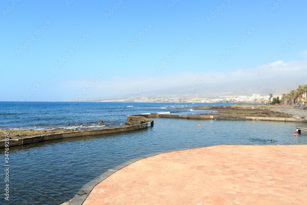 Natural swimming pool and Atlantic Ocean coastline panorama of holiday resort Playa de las Americas on Canary Island Tenerife, Spain