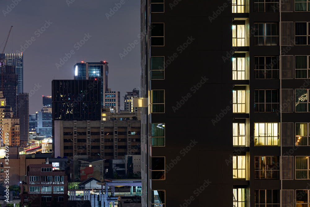 Scenic windows of skyscrapers at night timelapse. People moving inside apartments.