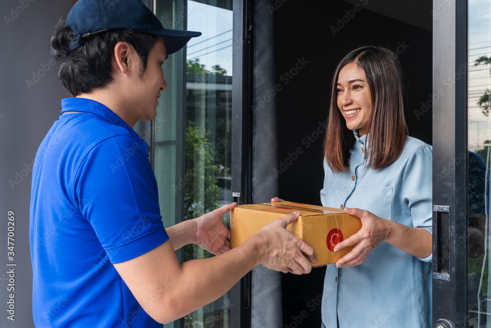 Delivery man delivering parcel box to customer woman at home