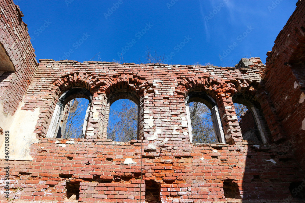 Ruins of old estate buildings made from red brick in Leningrad oblast, Russia