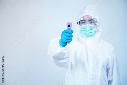doctor in personal protective equipment or PPE. holding digital thermometer,Coronavirus covid-19 outbreak concept