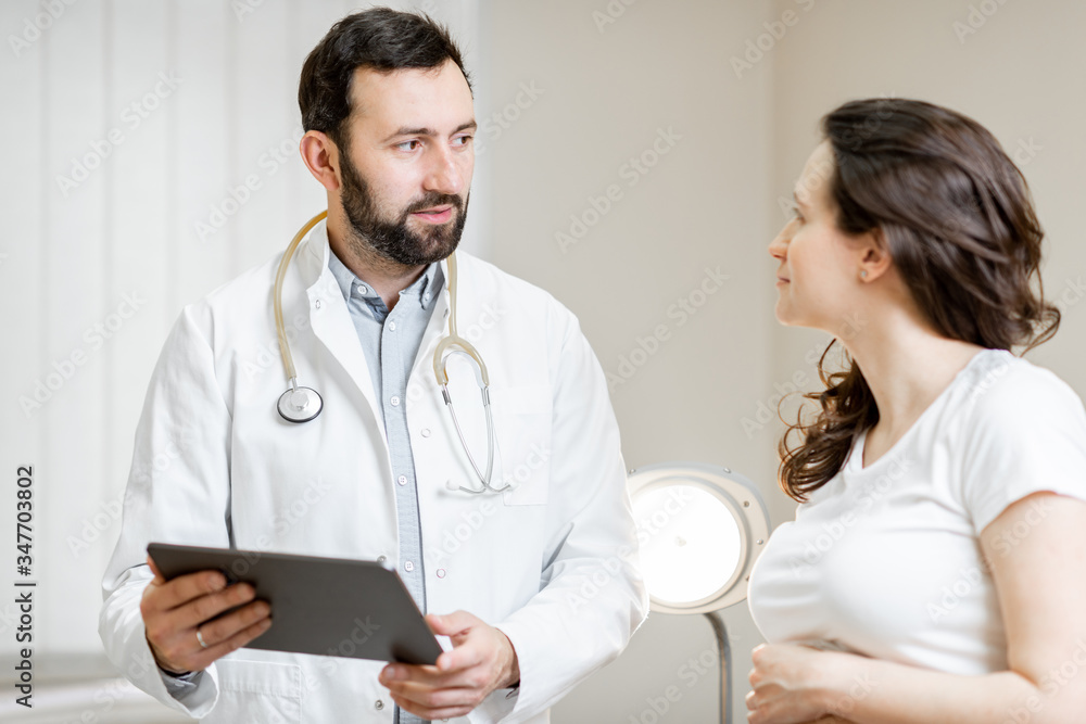 Doctor with pregnant woman during a medical consultation in gynecological office. Concept of medical care and health during a pregnancy Doctor with pregnant woman during a medical consultation in gynecological office. Concept of medical care and health during a pregnancy