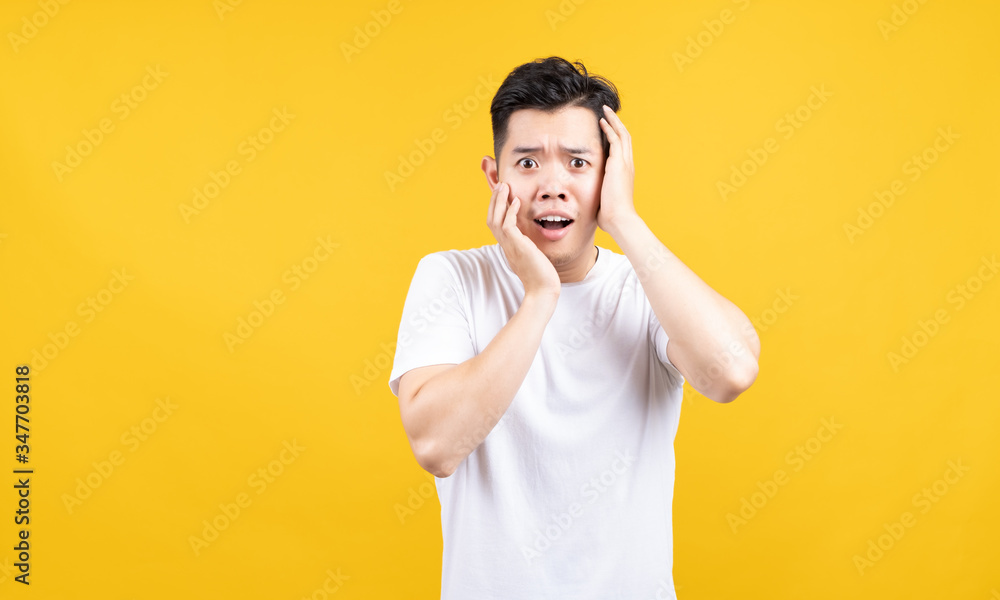 Attractive portrait happy young asian man excited wow emotion advertising promotion looking at camera with copy space wearing white t-shirt on yellow background isolated studio shot. Attractive portrait happy young asian man excited wow emotion advertising promotion looking at camera with copy space wearing white t-shirt on yellow background isolated studio shot.