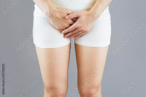 Fotografía woman wore white shorts put her hand on the genitalia area