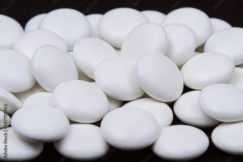 White pills on a dark background. Subject macro photography. White pills on a dark background. Subject macro photography.