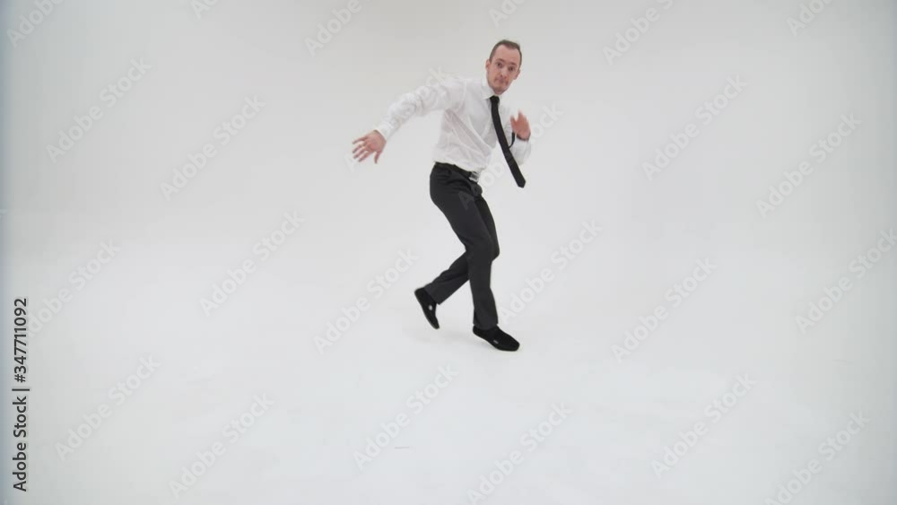 Office worker with a hobby break dance dancing on a white background. The guy dances making steps with jumps, squats on his leg and raises his legs leaning on his hands and head Office worker with a hobby break dance dancing on a white background. The guy dances making steps with jumps, squats on his leg and raises his legs leaning on his hands and head