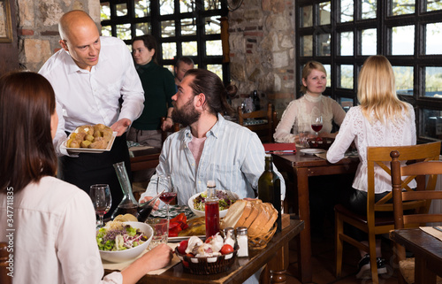 Rustic restaurant owner serving guests