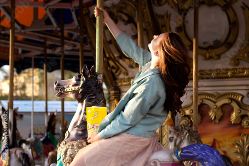 Canvas Print girl riding a carousel in a park