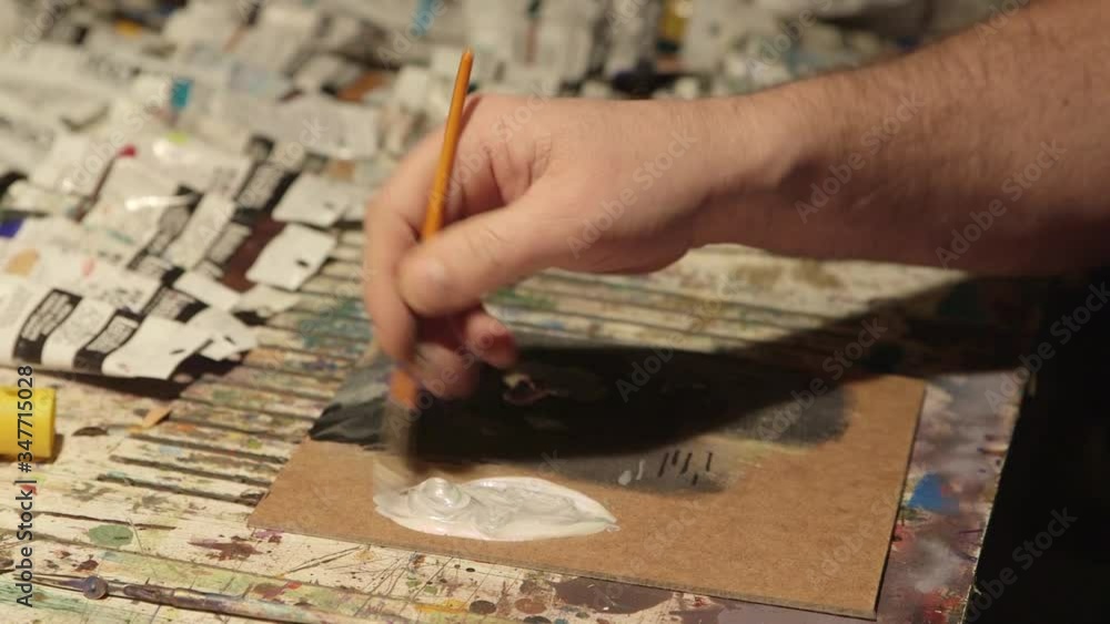 Hands mixing white and grey colors produce silver. Hands mixing white and grey colors produce silver.