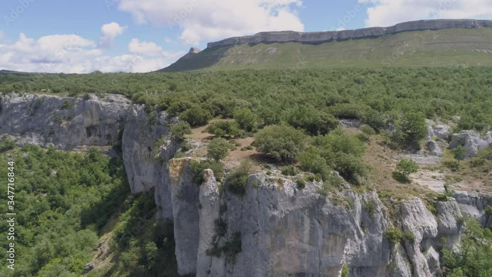 AERIAL DRONE ORBIT SHOT OF BEAUTIFUL GREEN FOREST OVER ROCKY MESETA MOUNTAIN AND VALLEY AERIAL DRONE ORBIT SHOT OF BEAUTIFUL GREEN FOREST OVER ROCKY MESETA MOUNTAIN AND VALLEY