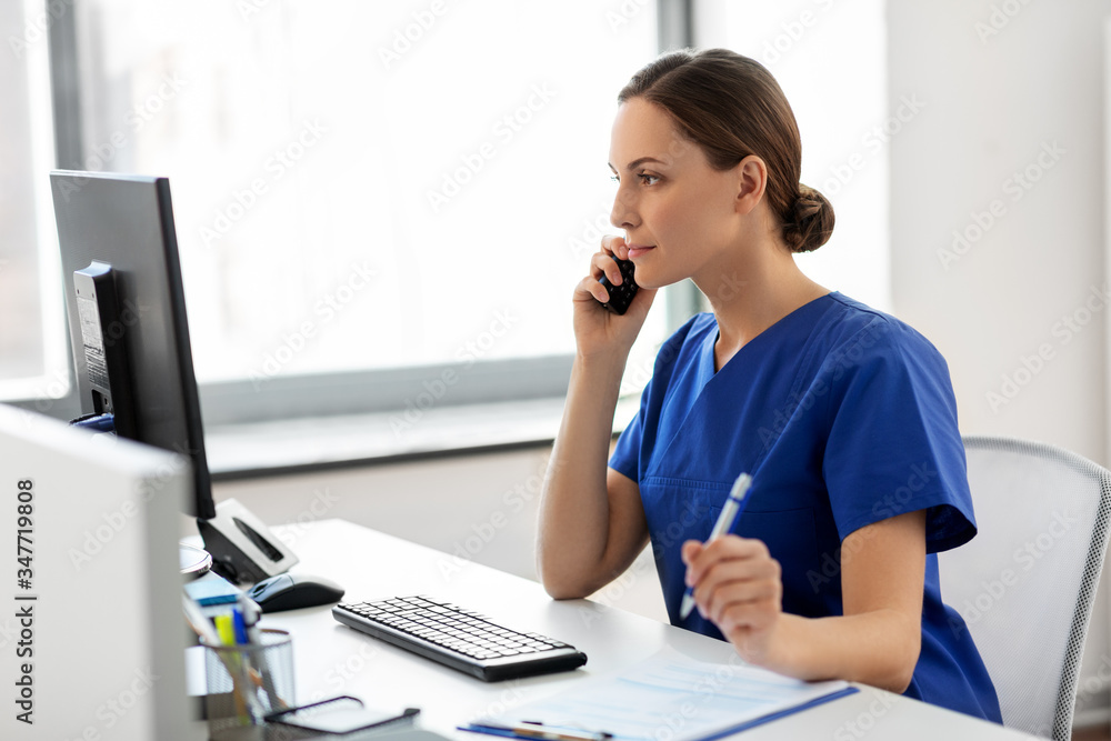 medicine, technology and healthcare concept - female doctor or nurse with computer and clipboard calling on phone at hospital