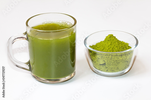 Green tea matcha in a glass bowl on a white background close-up. Useful tea matcha macro. Matcha drink in a Cup.