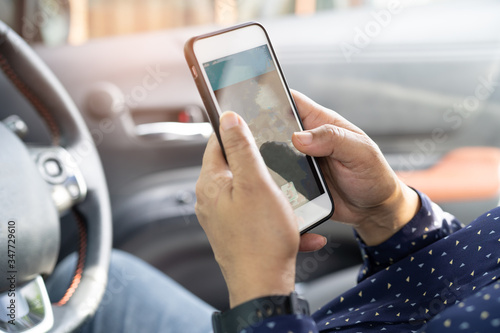 Holding mobile phone in car to communication with family and friends.