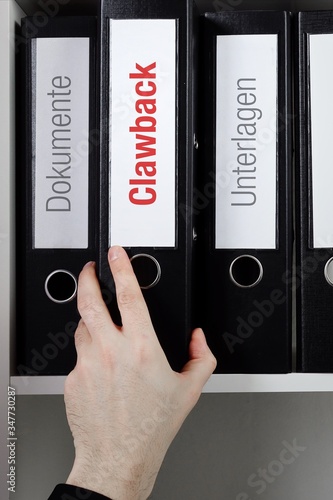 Clawback – Finanzen/Statistik. Ordner im Büro-Regal. Hand greift Unterlagen im Schrank. Beschriftung mit Wort