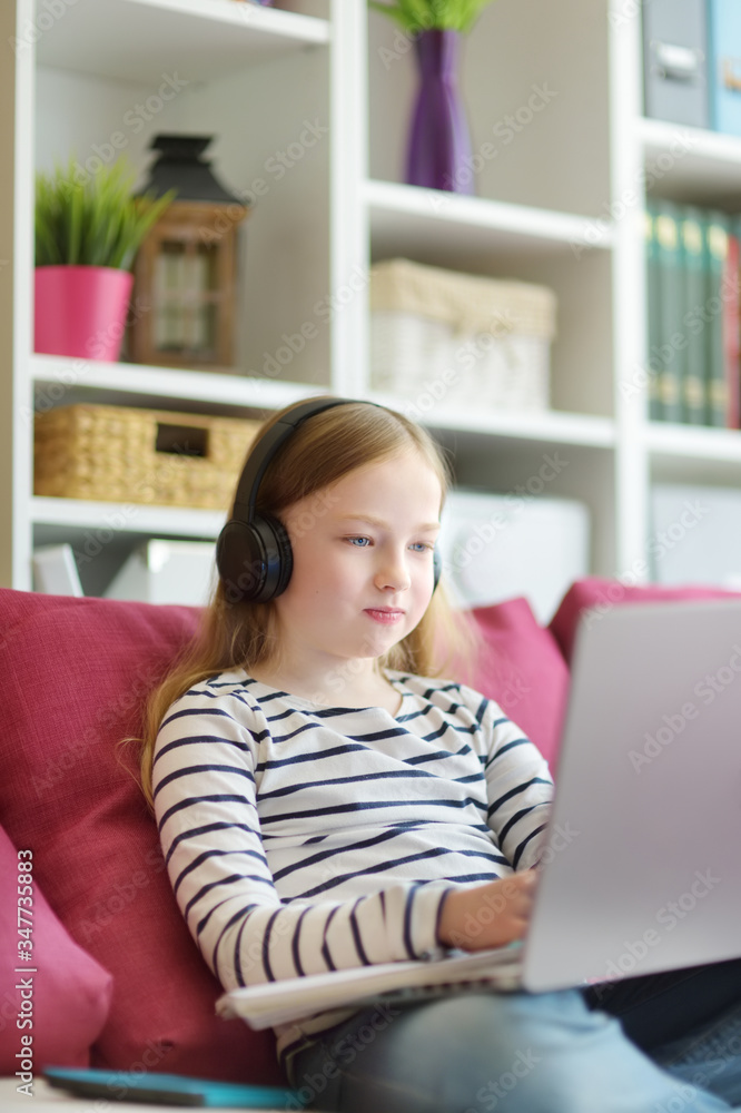 Young schoolgirl doing her homework with digital tablet at home. Child using gadgets to study. Education and distance learning for kids. Homeschooling during quarantine. Young schoolgirl doing her homework with digital tablet at home. Child using gadgets to study. Education and distance learning for kids. Homeschooling during quarantine.