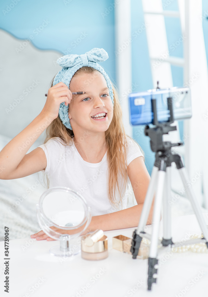 Young girl filming the video for her followers about makeup. Kids blogger concept Young girl filming the video for her followers about makeup. Kids blogger concept