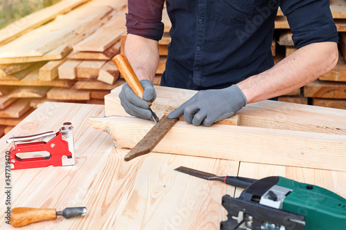 Carpenter working with plane on wooden background. Man hand with professional instrument repairing, fixing, building furniture