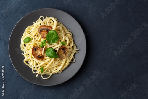 Spaghetti with mushrooms and creamy garlic sauce on a dark background