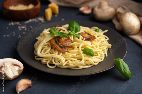 Italian pasta with mushrooms and cheese on a dark background