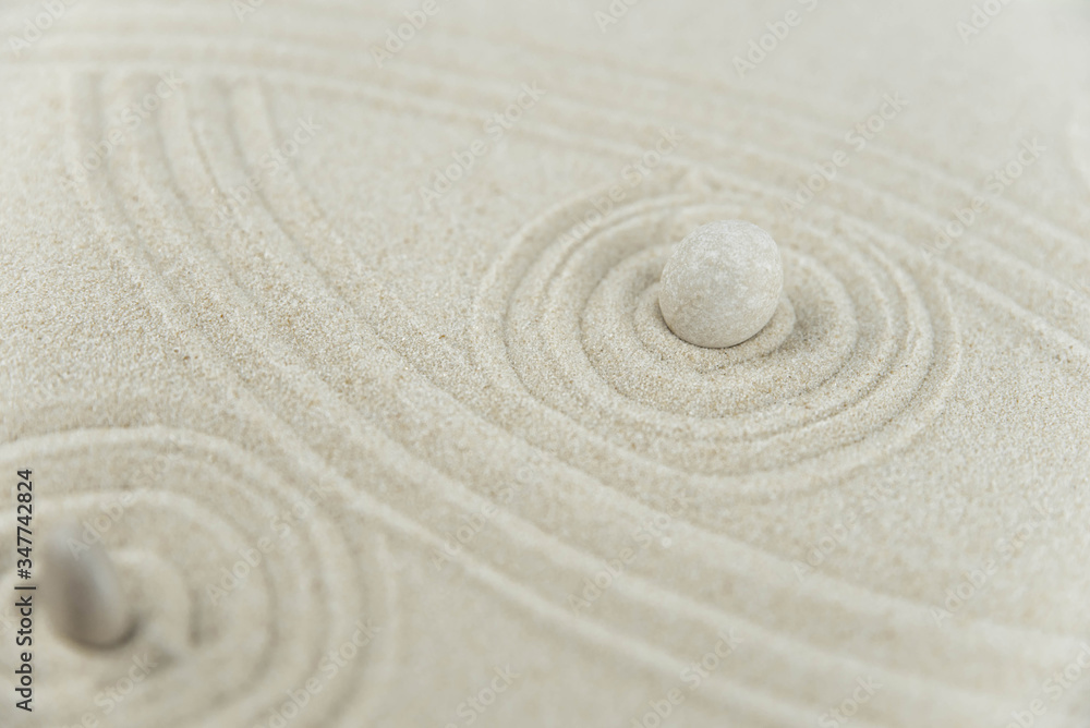 Fototapeta Zen garden. Pyramids of white and gray zen stones on the white sand with abstract wave drawings. Concept of harmony, balance and meditation, spa, massage, relax.