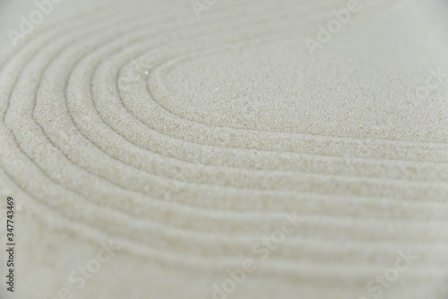 Abstract Zen drawing on white sand. Concept of harmony, balance and meditation, spa, massage, relax. Zen garden.