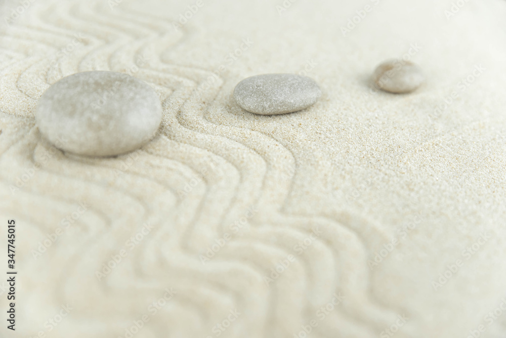 Zen garden. Pyramids of white and gray zen stones on the white sand with abstract wave drawings. Concept of harmony, balance and meditation, spa, massage, relax. Zen garden. Pyramids of white and gray zen stones on the white sand with abstract wave drawings. Concept of harmony, balance and meditation, spa, massage, relax.