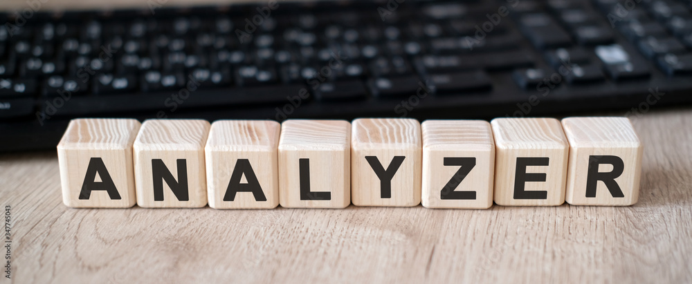Analizer - a tool used to analyze data. Text on wooden cubes and in the background black keyboard Analizer - a tool used to analyze data. Text on wooden cubes and in the background black keyboard