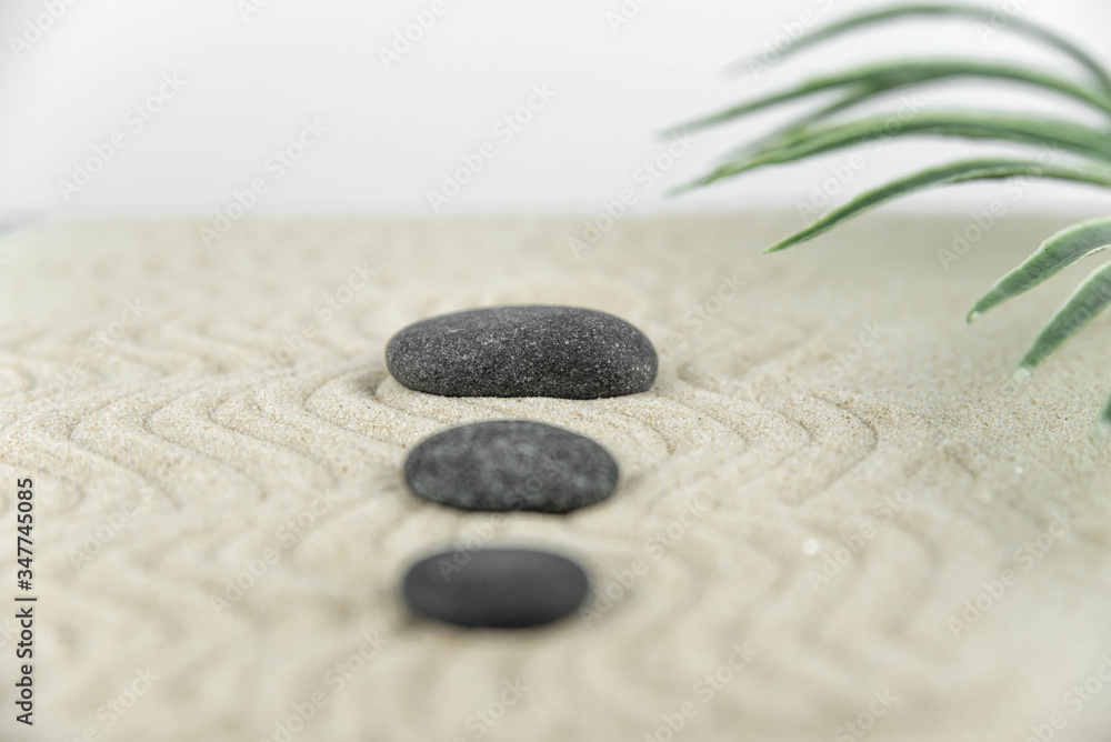 Zen garden. Pyramids of white and gray zen stones on the white sand with abstract wave drawings. Concept of harmony, balance and meditation, spa, massage, relax. Zen garden. Pyramids of white and gray zen stones on the white sand with abstract wave drawings. Concept of harmony, balance and meditation, spa, massage, relax.
