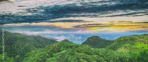 Panoramic aerial view of Mountains, Seascape and Vegetation at sunset