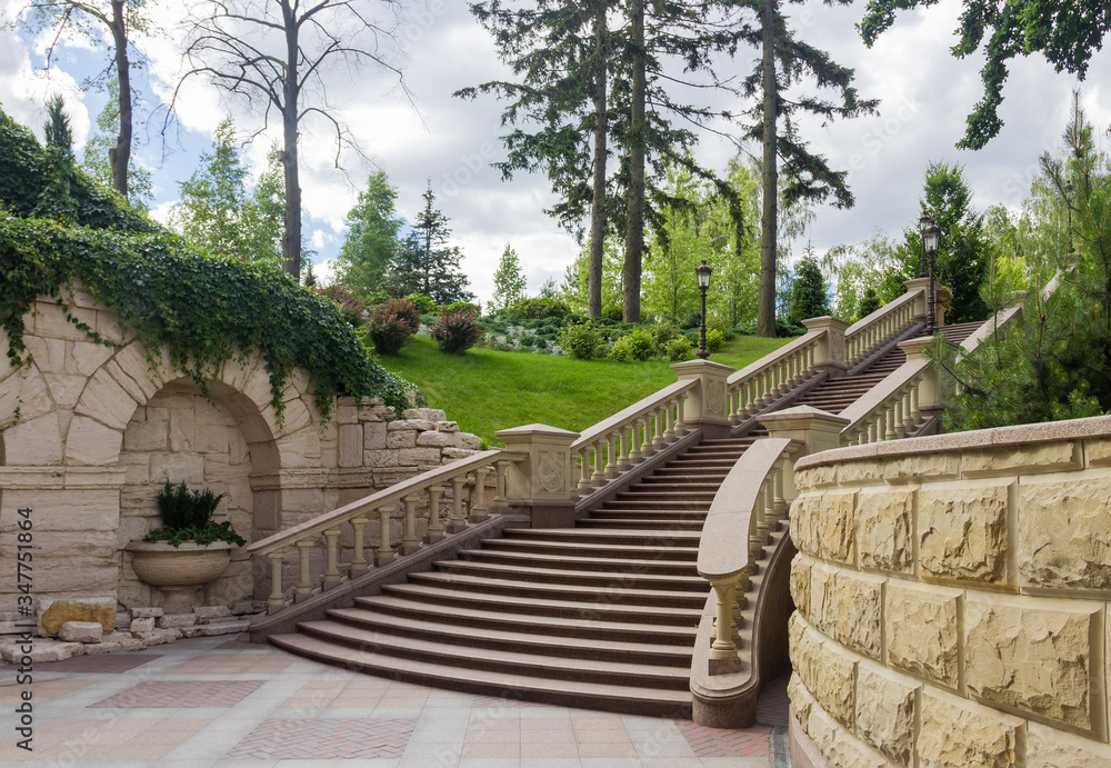 Stone staircase with stone railing in summer park
