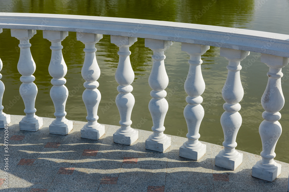 Fragment of balustrade with shaped balusters over water
