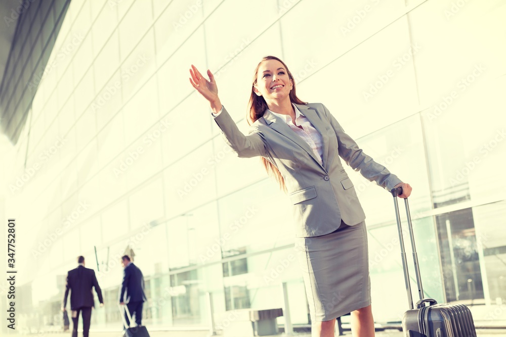 Fototapeta premium Cutout of Young attractive businesswoman calling taxi in airport