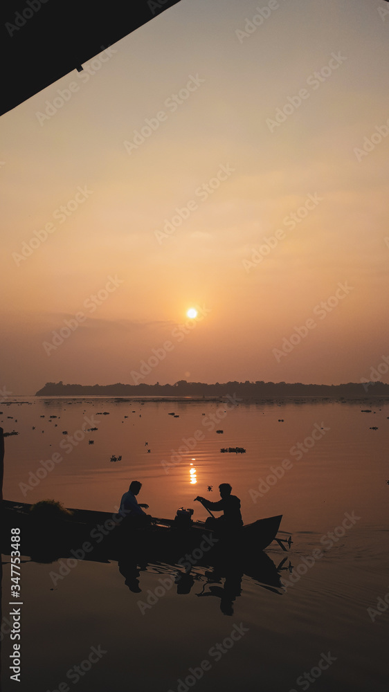 sunset at the river with fisherman