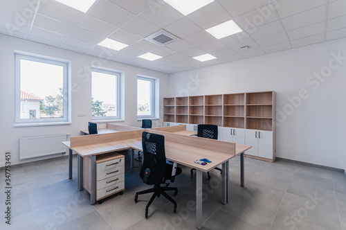 Interior of small new empty office space with desks and chairs