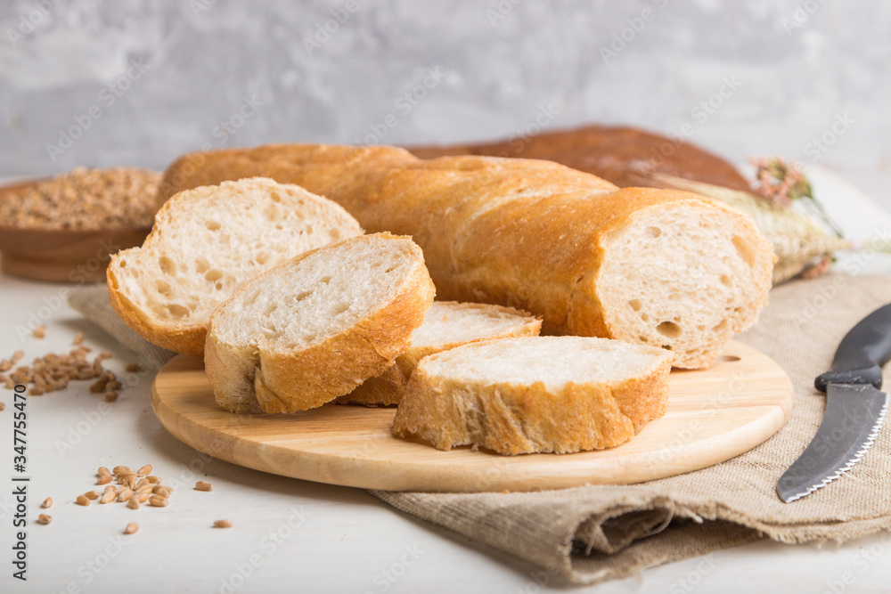 Sliced bread with different kinds of fresh baked bread on a white wooden background. side view, selective focus.
