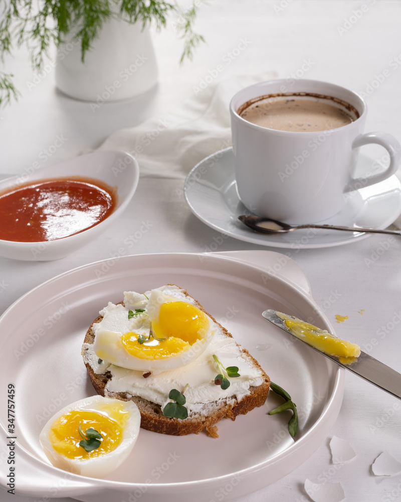 Breakfast with a cup of coffee. Open sandwich with cottage cheese and boiled eggs on a light plate. Above view Breakfast with a cup of coffee. Open sandwich with cottage cheese and boiled eggs on a light plate. Above view