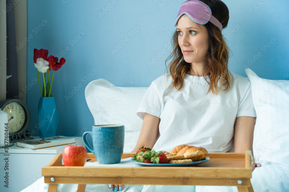 Breakfast on tray in bed for young beautiful funny woman. Good morning concept Breakfast on tray in bed for young beautiful funny woman. Good morning concept
