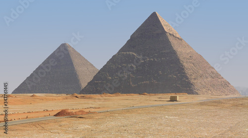 The famous Giza pyramids in Egypt. The front is the Great Pyramid of Cheops. A hot day with sand in the air on the edge of the desert in Northern Africa.