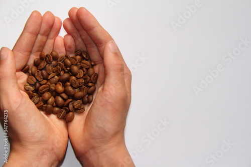 handful of coffee beans on a white background