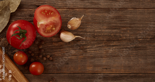 A nice home-made still life of vegetables and seasonings on a natural wooden background with space for text.