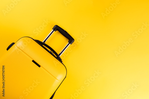 Yellow suitcase on a yellow background.Travel concept.Holiday Adventure Trip. photo