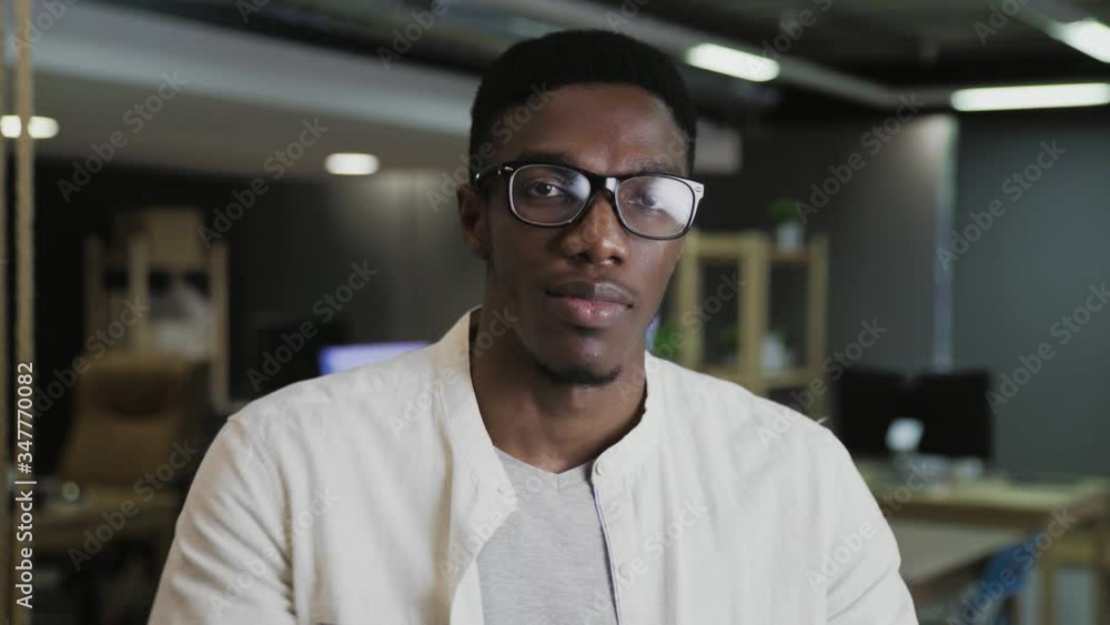 Smiling beautiful african american male professional manager employee standing in modern office looking at camera Smiling beautiful african american male professional manager employee standing in modern office looking at camera