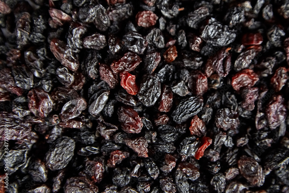 Raisins texture background. Heap of dried red grapes