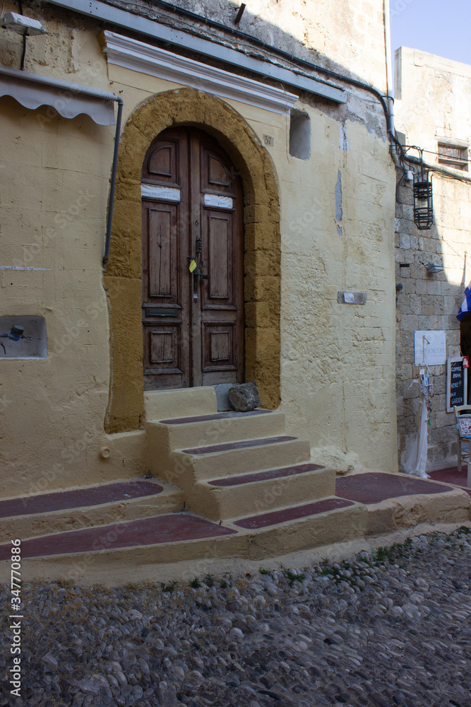 Naklejka premium Greece Rhodes, 11/07/2018 : The old fortress of the island. Entrance wooden door in the old part of the city.
