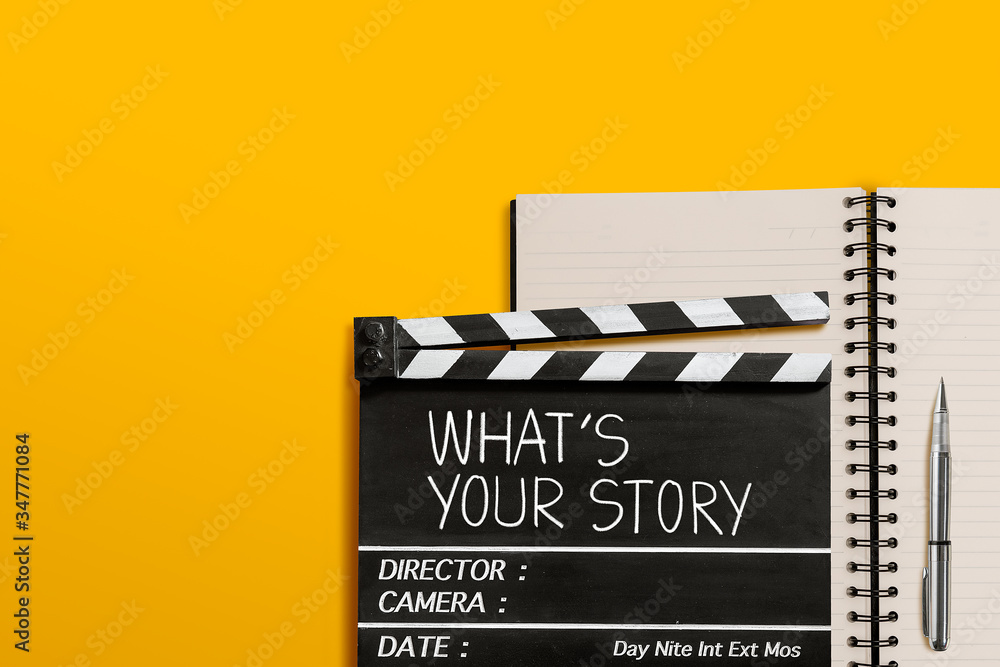 What's your story.Text title on movie clapperboard and notebook on yellow background