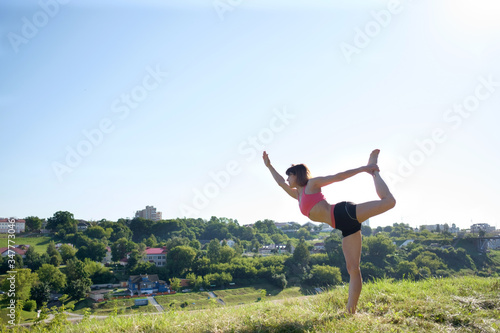 Yoga. International day of joga. Attractive fit woman practicing yoga outdoors.