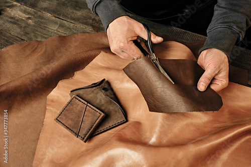 Billede på lærred Tailor cutting animal skins, leather at textile factory