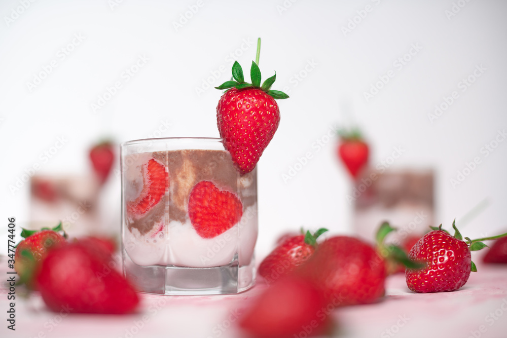 light strawberry dessert in a glass on a light background with fresh strawberries and cream and chocolate cream layers light strawberry dessert in a glass on a light background with fresh strawberries and cream and chocolate cream layers